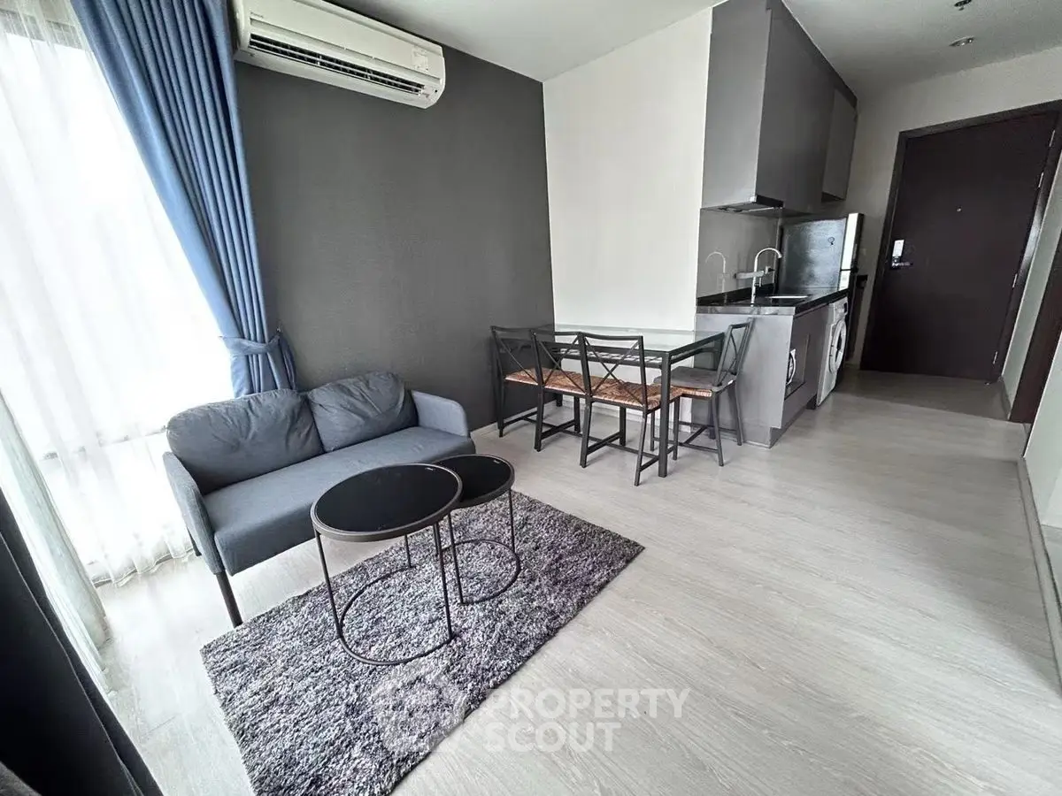 Modern living room with sleek kitchen and cozy seating area