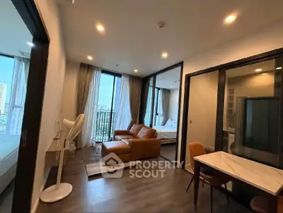 Modern apartment with cozy living room and bedroom, featuring stylish furniture and large windows.