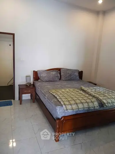 Cozy bedroom with wooden bed frame and elegant bedding in a serene setting.