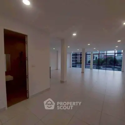 Spacious open-plan living area with large windows and city view.