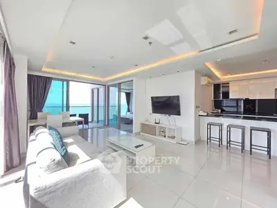 Spacious modern living room with ocean view and open kitchen layout.