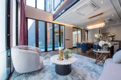 Luxurious modern living room with high ceilings, elegant chandelier, and pool view, perfect for upscale living.