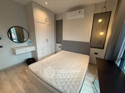 Modern bedroom with stylish furniture and air conditioning, featuring a comfortable bed and elegant lighting.