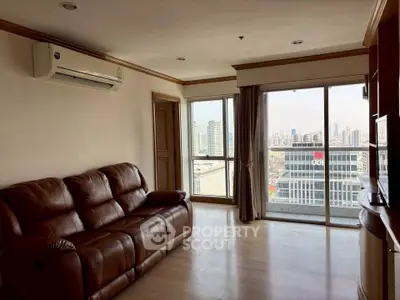 Spacious living room with city view and leather sofa in modern apartment.
