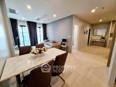 Modern open-plan living and dining area with elegant marble table and stylish decor.
