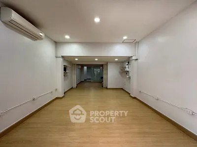 Spacious open-plan interior with wooden flooring and modern lighting, ideal for versatile use.