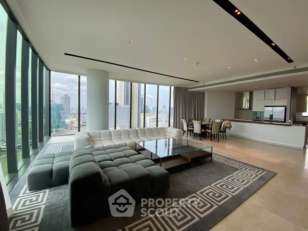 Luxurious high-rise living room with panoramic city views and modern open kitchen.