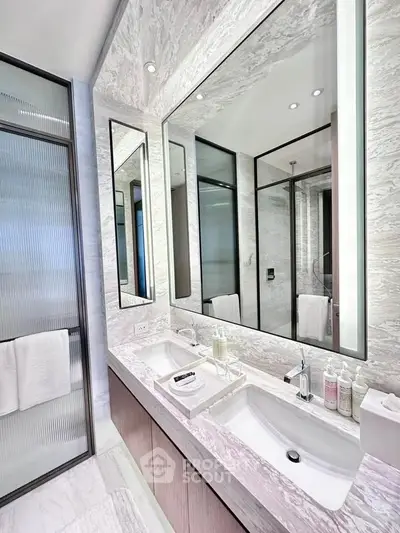 Luxurious modern bathroom with dual sinks and elegant marble finishes.