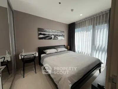 Modern bedroom with stylish decor and large windows offering natural light.