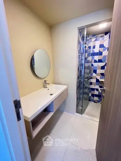 Modern bathroom with stylish geometric shower tiles and sleek vanity