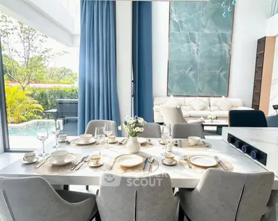 Luxurious dining area with elegant table setting and pool view, perfect for entertaining guests.