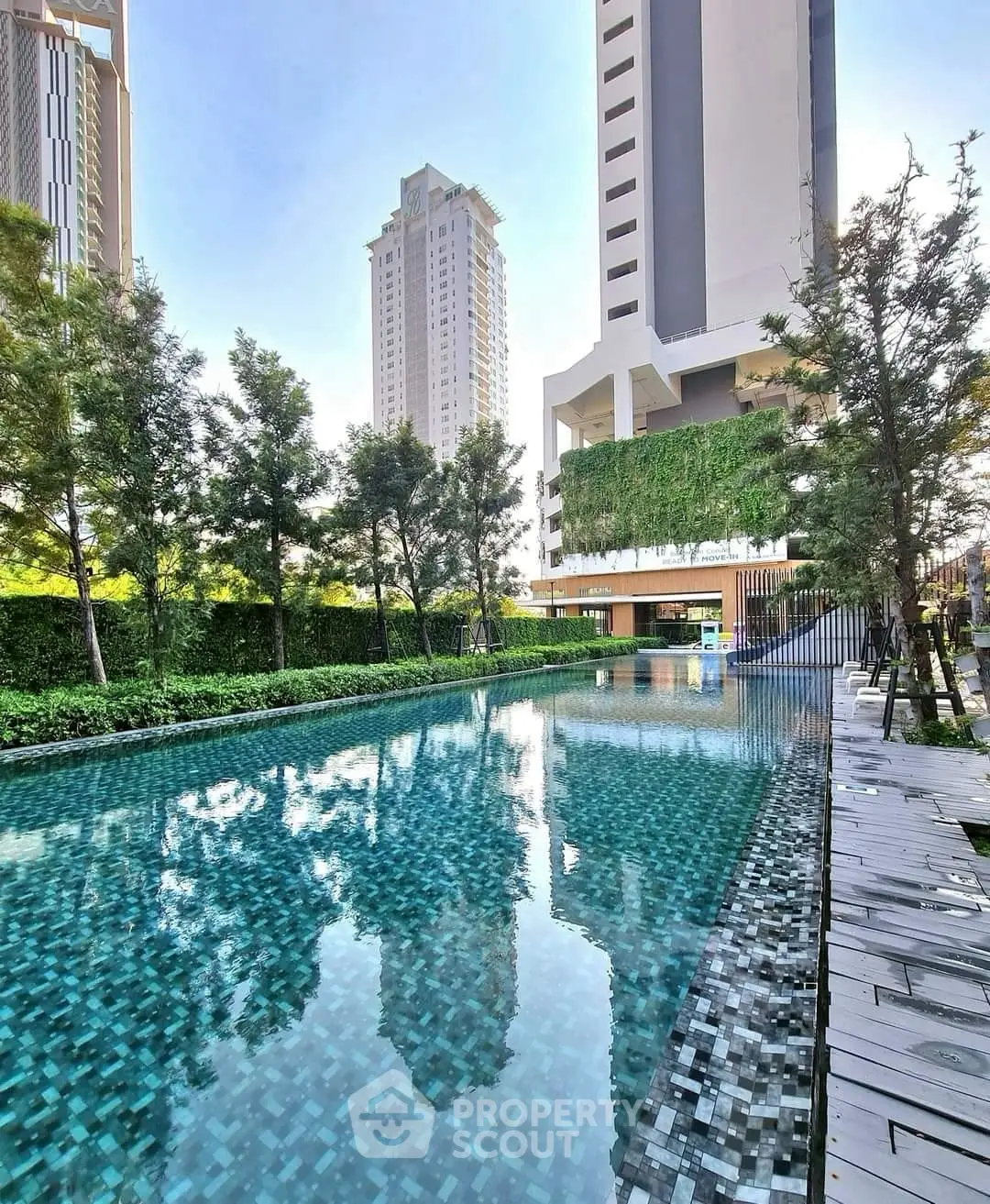 Luxurious high-rise building with serene pool and lush greenery