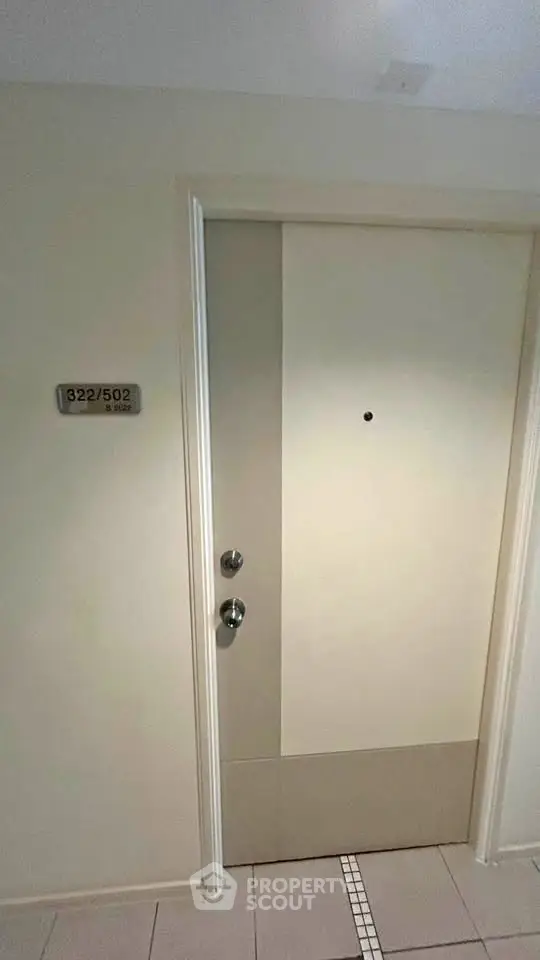 Modern apartment entrance with sleek door and room number plaque, ideal for urban living.
