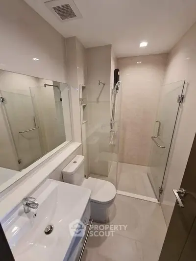 Modern bathroom with glass shower and sleek fixtures in a contemporary apartment.