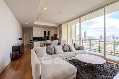 Luxurious living room with panoramic city view and modern open kitchen layout.