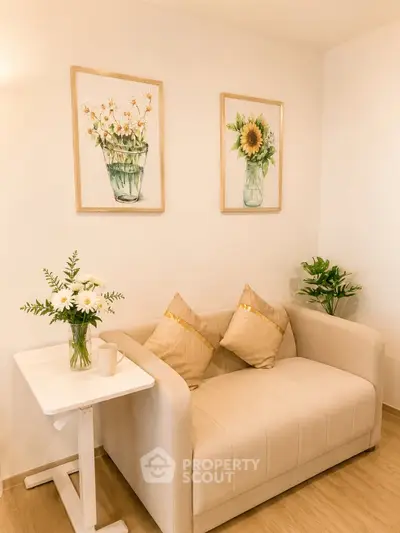 Cozy living room with elegant beige sofa and floral decor, perfect for relaxation.