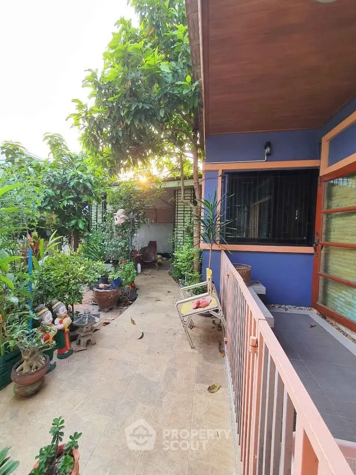 Charming garden patio with lush greenery and cozy seating area, perfect for relaxation and outdoor enjoyment.