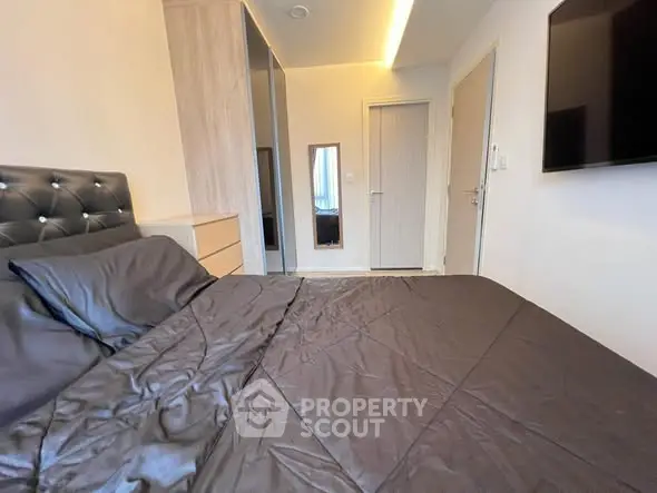 Modern bedroom with sleek design and wall-mounted TV