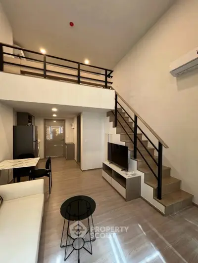 Modern loft apartment with open layout, stylish staircase, and sleek furnishings.