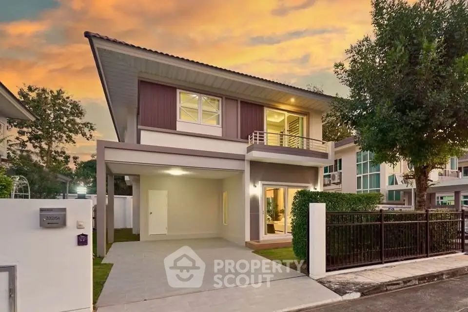Modern two-story house with spacious driveway and lush greenery at sunset