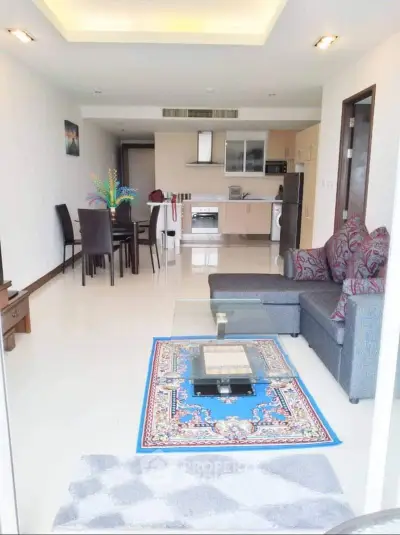 Spacious open-plan living room with modern kitchen and stylish decor in a contemporary apartment.