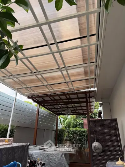 Charming outdoor patio with modern pergola and lush greenery, perfect for relaxation and entertaining.