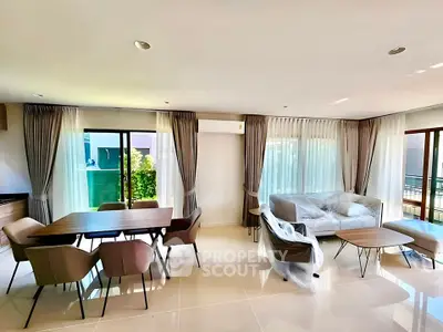 Spacious modern living room with elegant dining area and large windows for natural light.