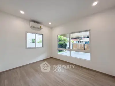 Spacious empty room with large windows and air conditioning, perfect for customization.
