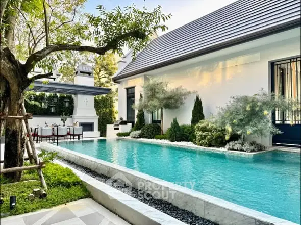 Luxurious modern home with a stunning pool and lush garden, perfect for relaxation and entertainment.