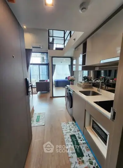Modern open-layout kitchen with sleek appliances and view of spacious living area.