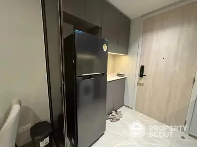 Modern kitchen with sleek black fridge and minimalist cabinetry