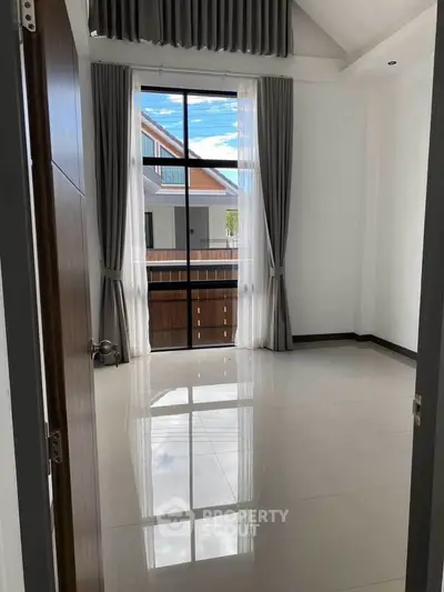 Bright and airy room with large window and elegant curtains in modern home.