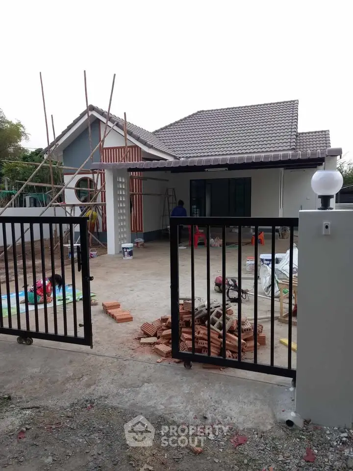 Charming single-story house under renovation with spacious driveway and modern gate.