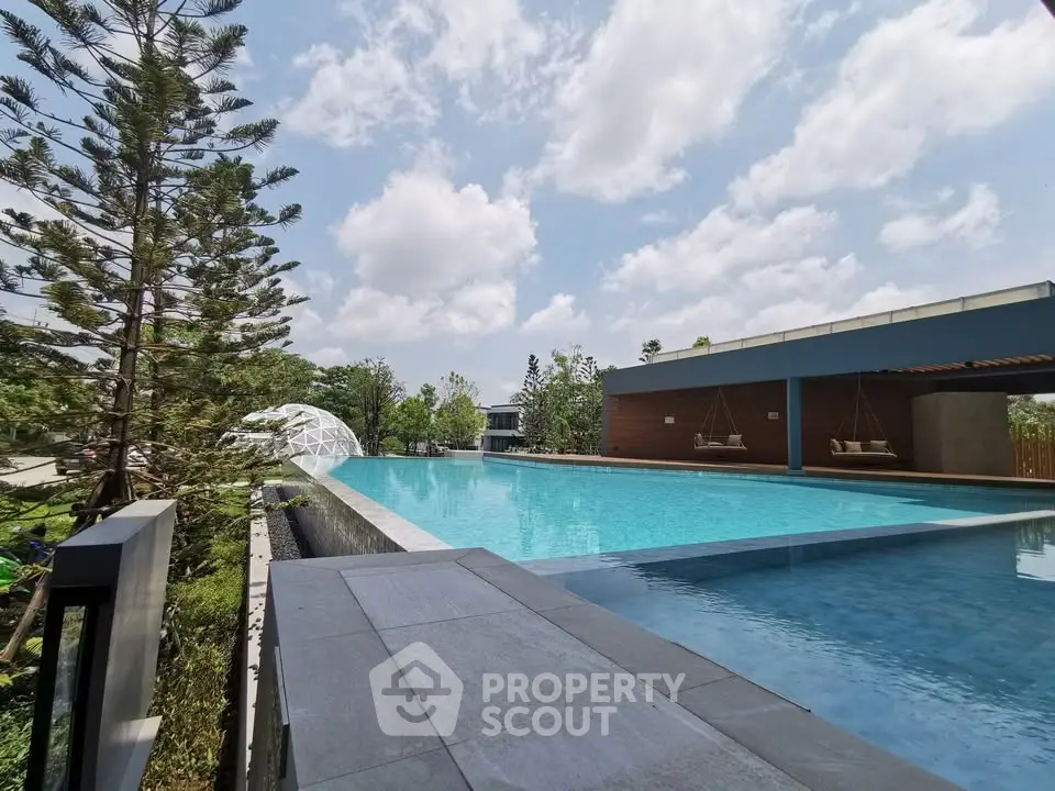 Luxurious outdoor pool with modern design and lush greenery, perfect for relaxation and leisure.