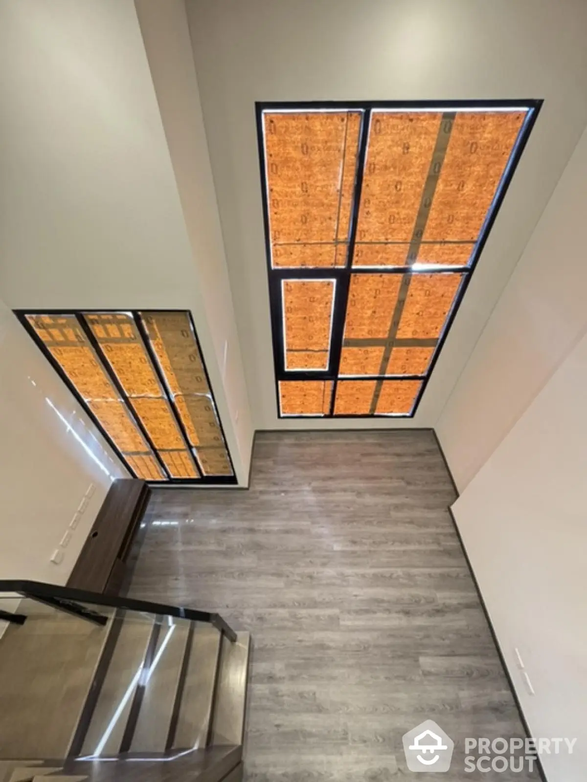 Modern staircase with large windows and stylish flooring in a contemporary home.