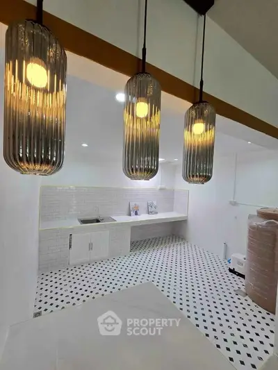 Modern kitchen with stylish pendant lights and checkered floor tiles.