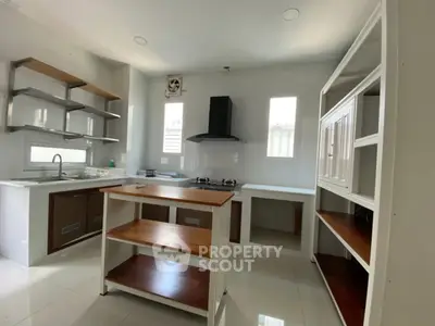 Modern kitchen with sleek open shelving and gas stove, perfect for culinary enthusiasts.