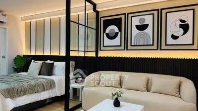 Modern bedroom with stylish decor, featuring a cozy bed, elegant sofa, and contemporary wall art.