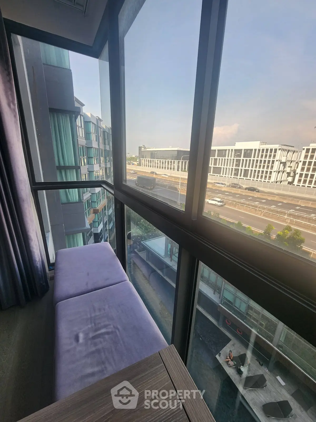 Modern apartment with floor-to-ceiling windows offering stunning city and pool views.