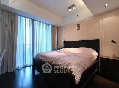 Spacious bedroom with large bed and floor-to-ceiling windows for natural light.