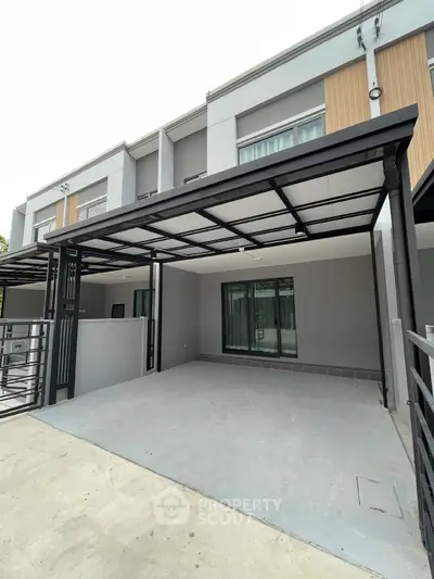 Modern townhouse exterior with spacious parking area and sleek design.