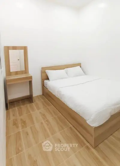 Cozy minimalist bedroom with wooden flooring and modern furniture