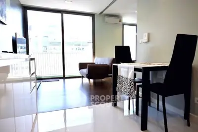 Modern living room with sleek furniture and large windows offering natural light.
