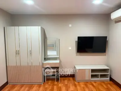 Modern bedroom with sleek furniture and mounted TV, showcasing contemporary design.