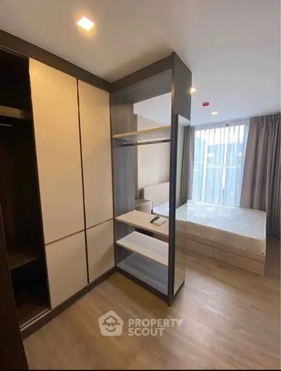 Modern bedroom with built-in wardrobe and large window offering natural light.