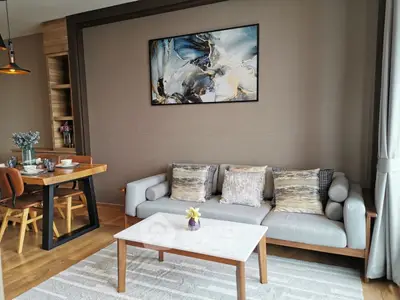 Stylish living room with modern decor, cozy sofa, and elegant dining area, perfect for urban living.