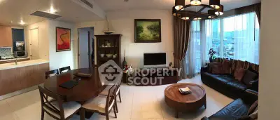 Spacious living room with modern decor and large windows offering city views.