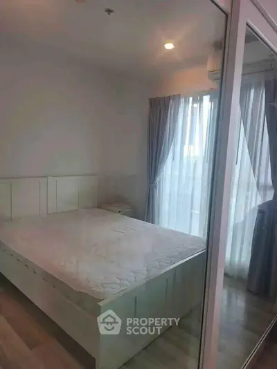 Cozy bedroom with large window and elegant curtains, featuring a comfortable bed and modern decor.