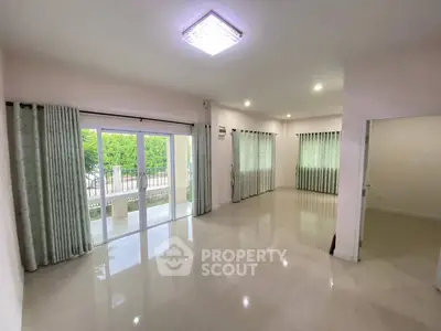 Spacious living room with large windows and polished floors