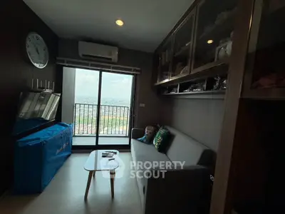 Cozy living room with balcony view, modern furniture, and ample storage in a high-rise apartment.